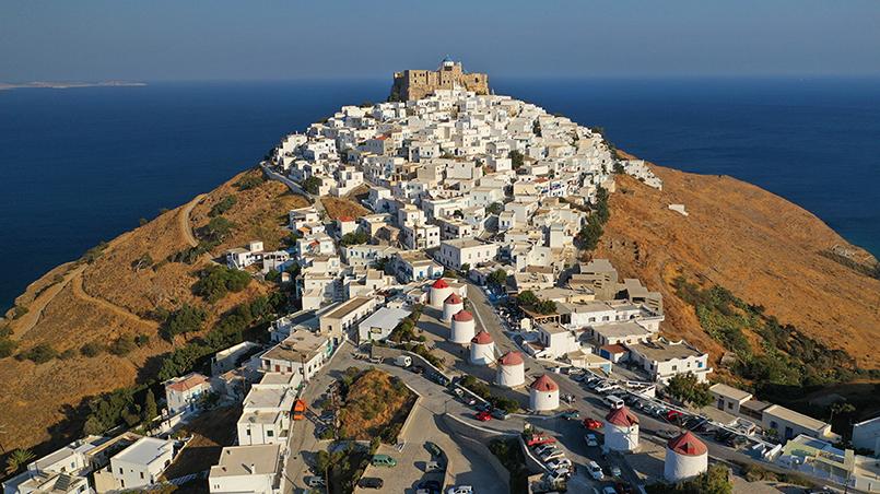 Aerial drone photo of iconic medieval fortified castle overlooking the deep blue Aegean sea in Chora of Astypalaia at sunset, Dodecanese islands, Greece